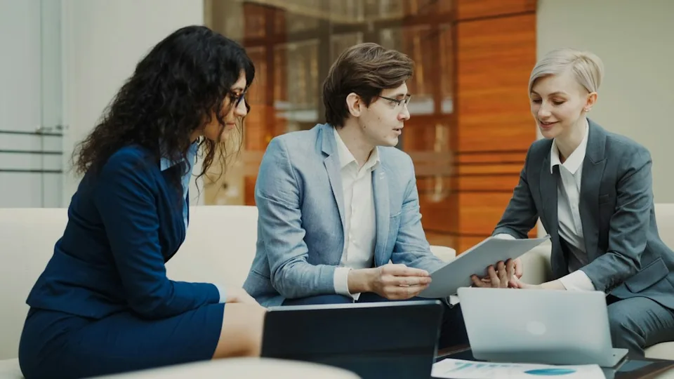 Colleagues discussing documents at a table.